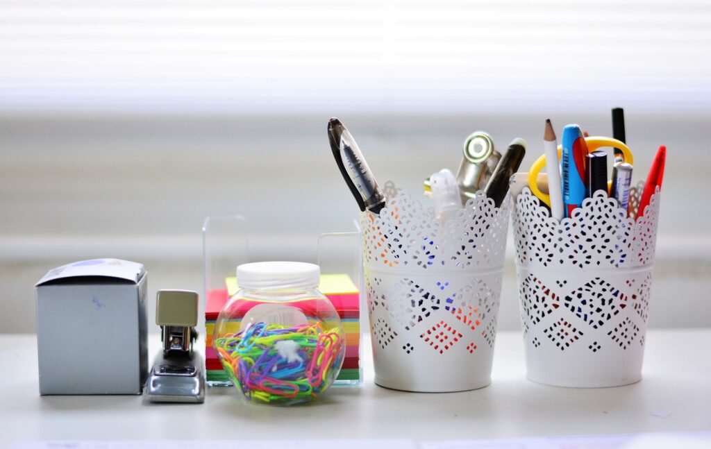 Office supplies in containers and on top of a desk.