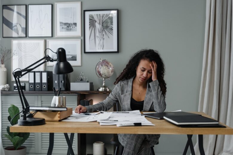 A woman overwhelmed with papers on her desk
