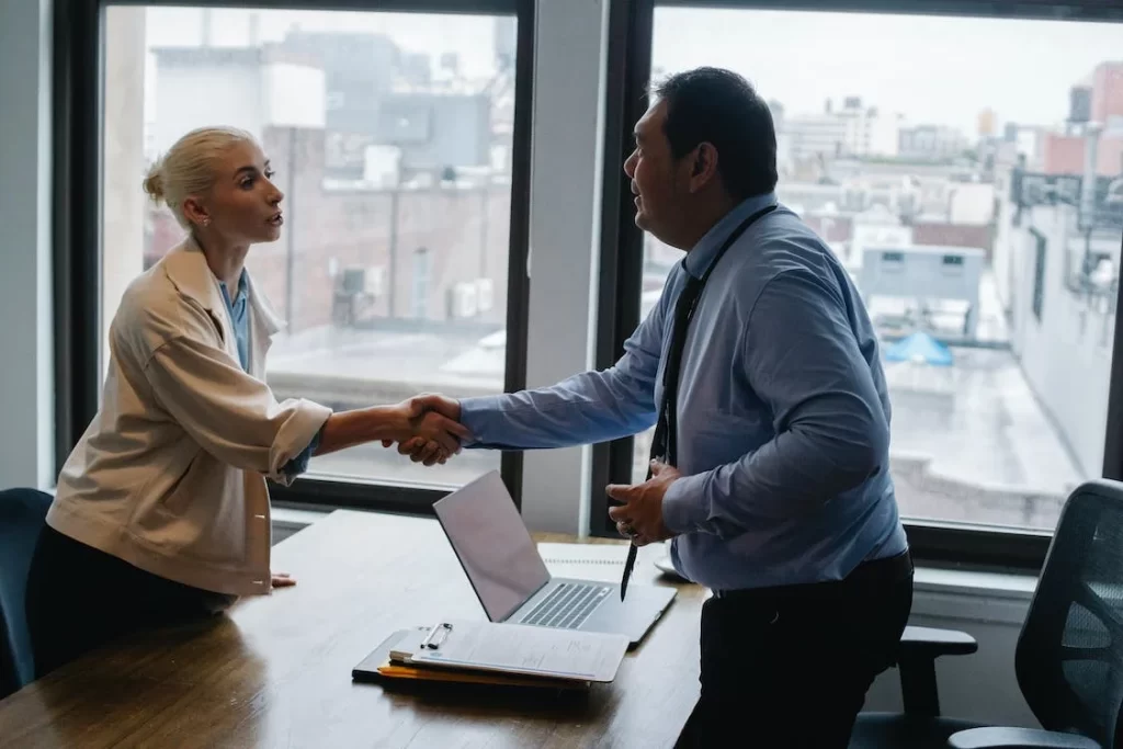 Woman and man shaking hands.