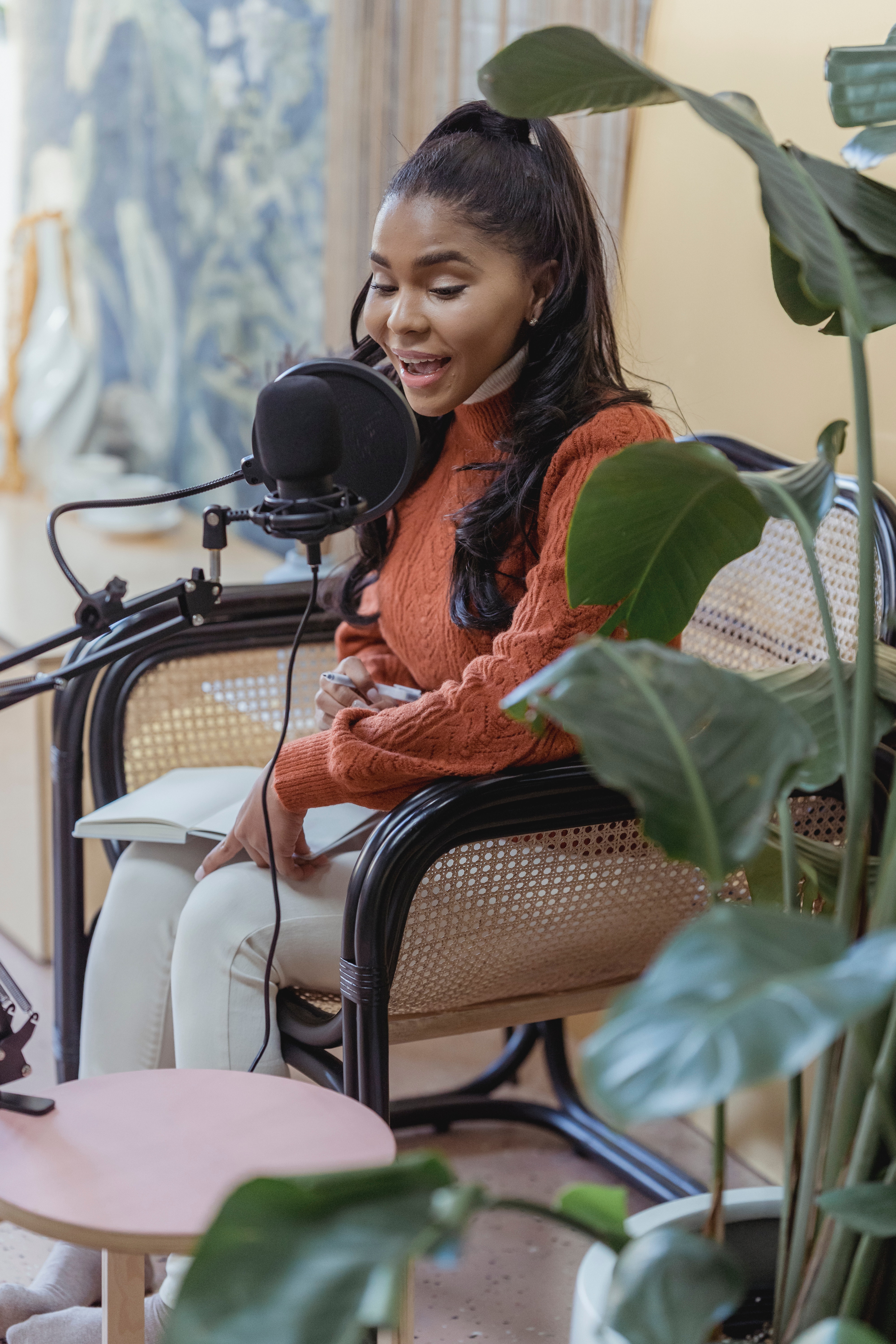 A woman siting down while singing for her Social Media Presence.