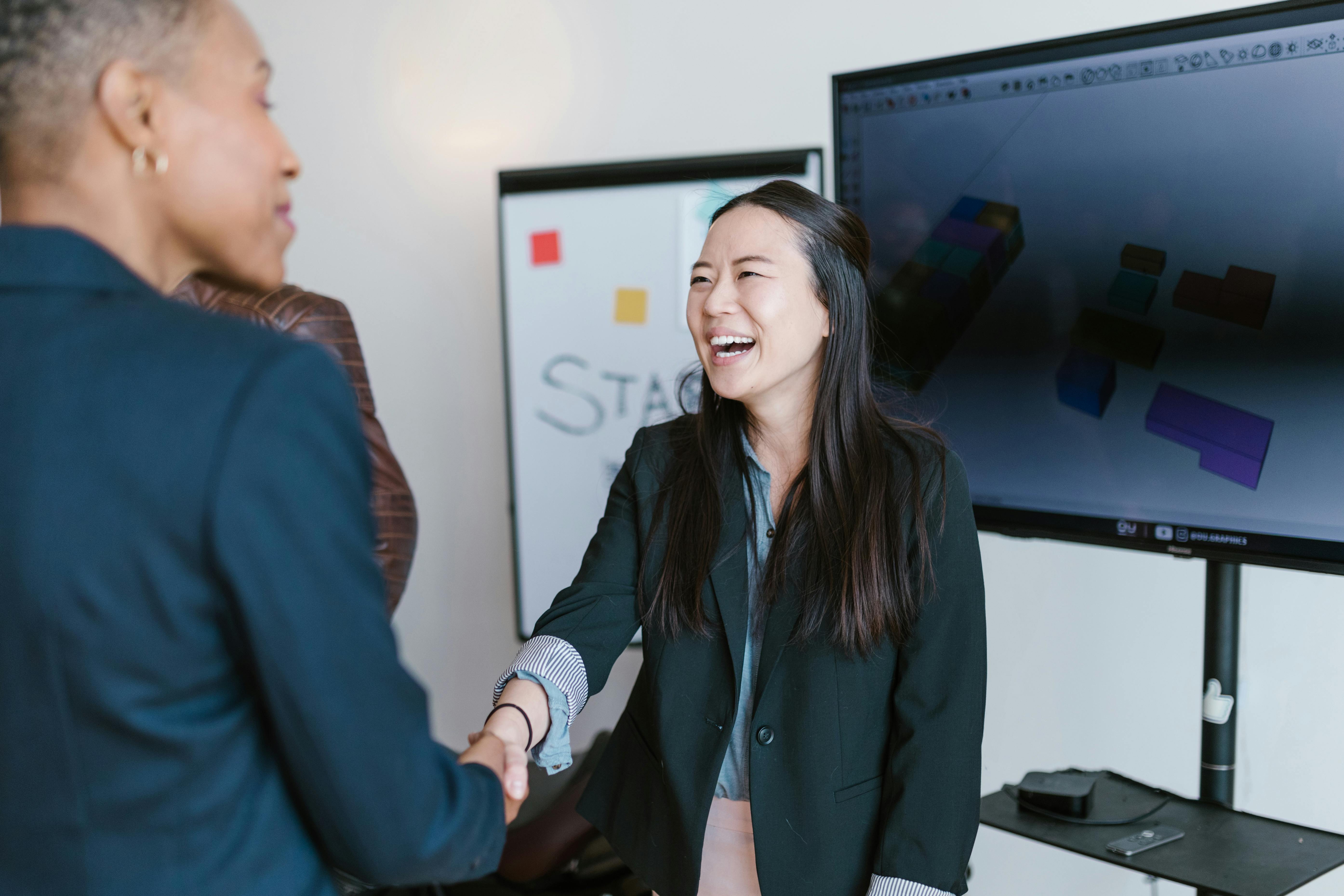 A woman shaking hands with another woman